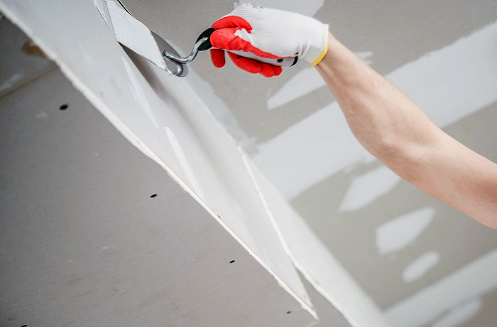 Residential Remodeling Drywall Patching. Caucasian Contractor in His 30s. Construction Theme.